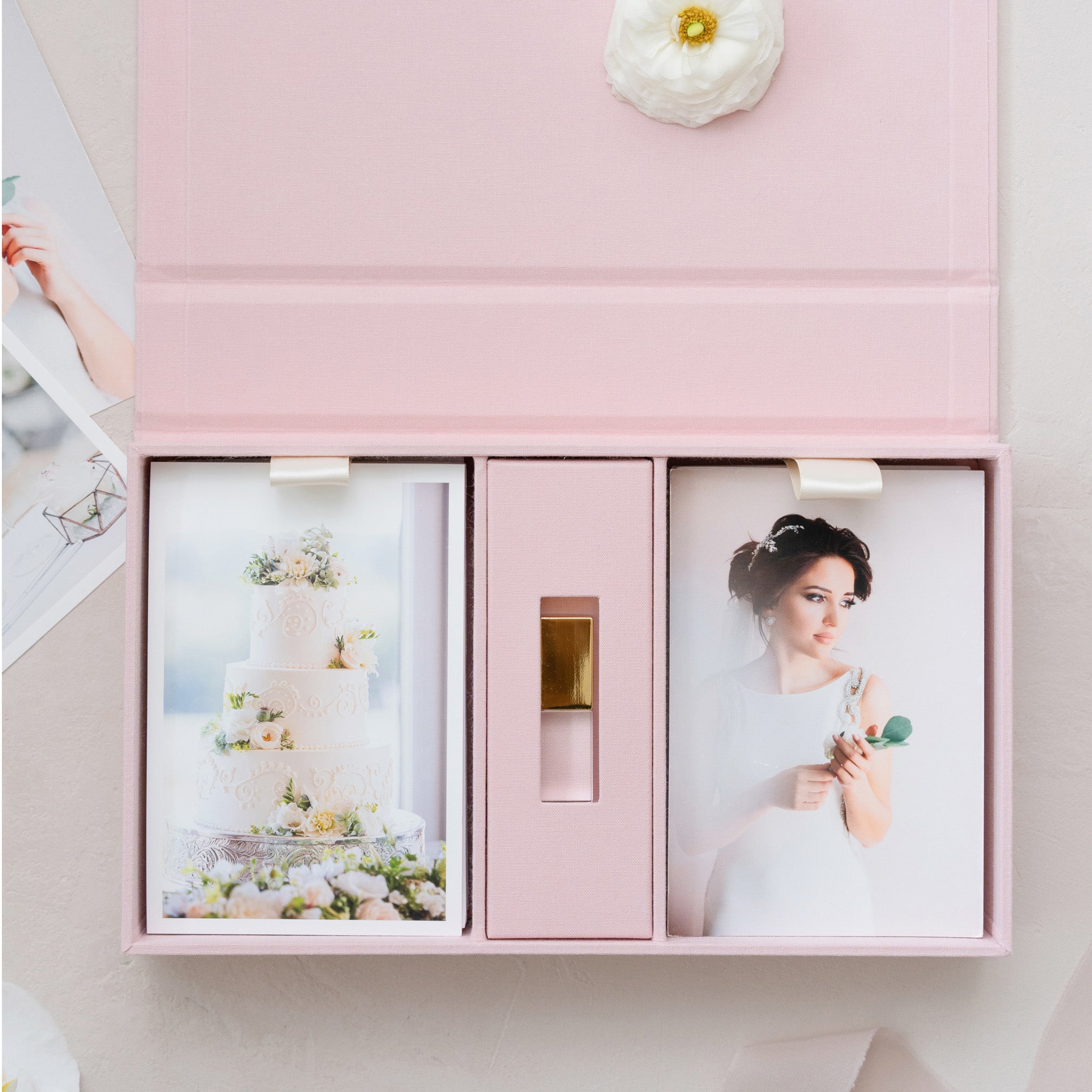 A pink photo album with two printed photographs inside, one of a bride and one of a cake.