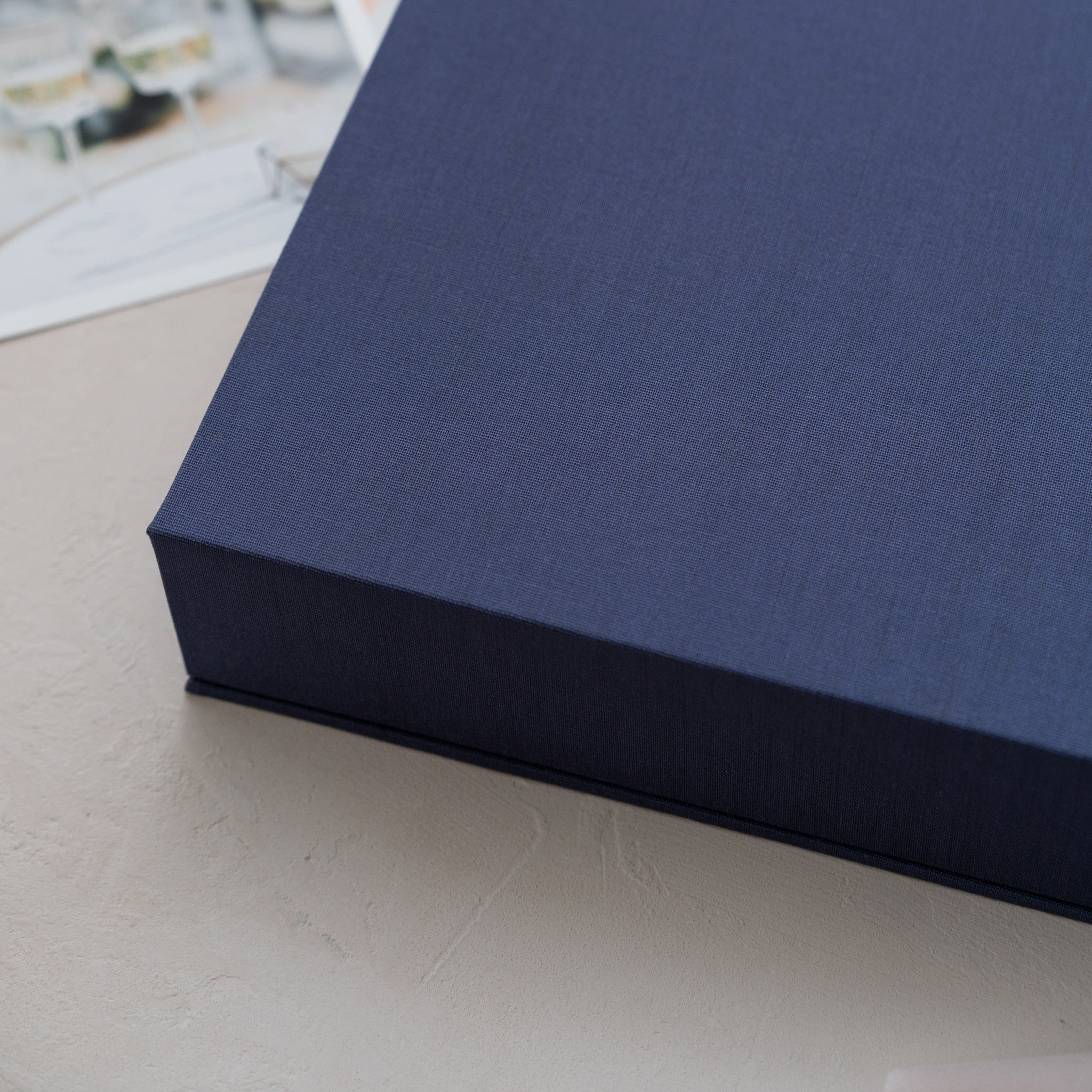 A close-up view of a dark blue, rectangular box on a light-colored surface.