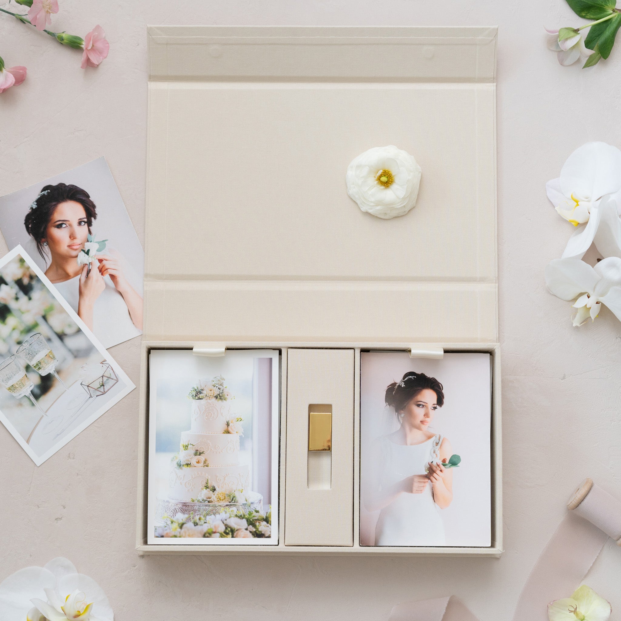 a white box containing two photographs, one of a woman and one of a cake, along with a small white flower.