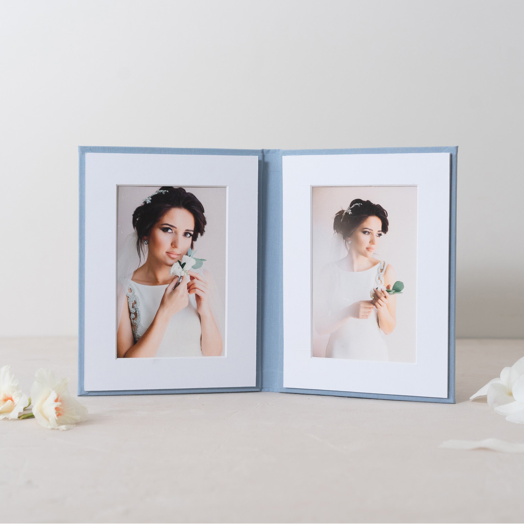 two framed photographs of a woman, one with a floral arrangement in her hand and the other with a bouquet of flowers.